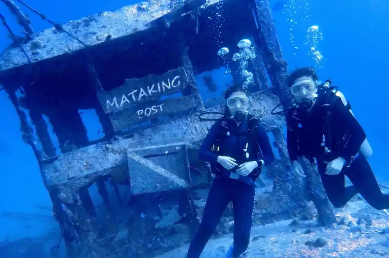 A certified dive master buddy assisting divers with Turtle Garden Resort in the Semporna area